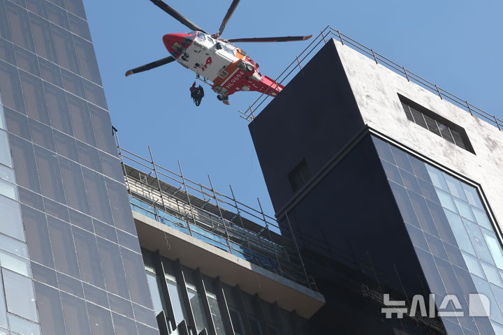 [부산=뉴시스] 하경민 기자 = 14일 오후 부산 기장군의 반얀트리 복합리조트 신축 공사장에서 발생한 화재 현장에서 옥상 대피자를 소방중앙특수구조단이 헬기를 이용해 구조하고 있다. 2025.02.14. yulnetphoto@newsis.com