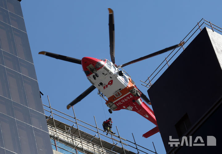 [부산=뉴시스] 하경민 기자 = 14일 오후 부산 기장군 반얀트리 복합리조트 신축공사장 화재 현장에서 소방중앙특수구조단 헬기가 옥상 대피자를 구조하고 있다.  이 화재로 인한 6명이 숨지고 25명 경상을 입었다. 또 100여 명이 긴급 대피했다. 2025.02.14. yulnetphoto@newsis.com