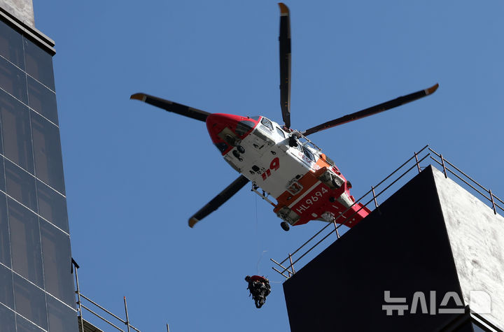 [부산=뉴시스] 하경민 기자 = 14일 오후 부산 기장군 반얀트리 복합리조트 신축공사장 화재 현장에서 소방중앙특수구조단 헬기가 옥상 대피자를 구조하고 있다. 이 화재로 인한 6명이 숨지고 25명 경상을 입었다. 또 100여 명이 긴급 대피했다. 2025.02.14. yulnetphoto@newsis.com