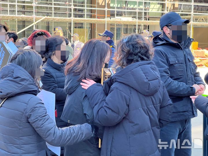 [부산=뉴시스] 원동화 기자 = 22일 오전 부산 기장군 오시리아 반얀트리 해운대 부산 신축 공사장 화재 현장을 방문한 유족이 영정사진을 들고 울고 있다. 2025.02.22 dhwon@newsis.com