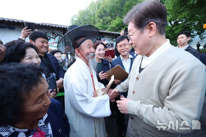 [장수=뉴시스] 조성봉 기자 = 민심을 청취하는 '경청 투어'에 나선 이재명 더불어민주당 대선후보가 지난 6일 전북 장수군 천천면 오옥마을에서 어르신들과 인사를 나누고 있다.2025.05.06. suncho21@newsis.com