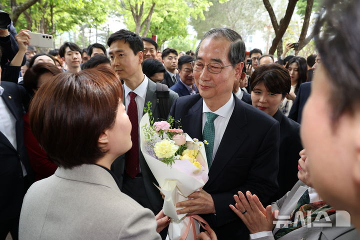 [서울=뉴시스] 조성우 기자 = 한덕수 무소속 대선 후보가 8일 김문수 국민의힘 대선 후보와의 단일화 관련 회동을 하기 위해 서울 여의도 국회 강변서재에 도착, 꽃다발을 받고 있다. 2025.05.08. xconfind@newsis.com