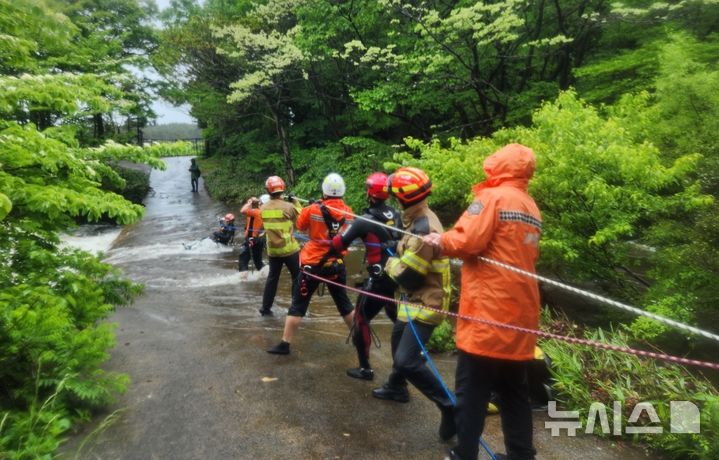 [제주=뉴시스] 9일 오전 제주시 조천읍에서 침수된 도로로 인해 고립된 고사리객이 소방당국에 의해 구조되고 있다. (사진=제주소방안전본부 제공) 2025.05.09. photo@newsis.com 