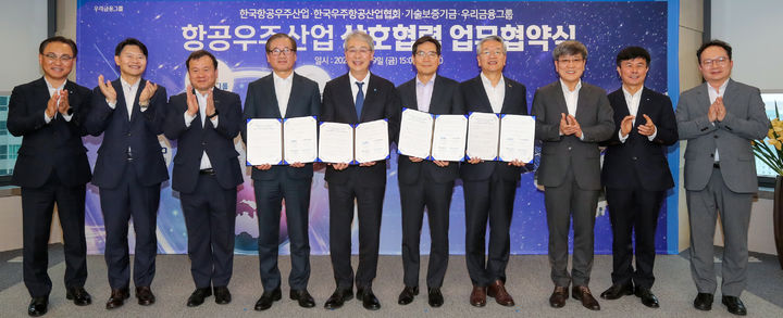 9일 진행된 항공우주산업 상호협력 업무협약식에 (왼쪽부터)우리은행 기업그룹 배연수 부행장, 우리금융지주 성장지원부문 전현기 부사장, 기술보증기금 이재필 이사, 한국항공우주산업 강구영 사장, 우리금융지주 임종룡 회장, 한국우주항공산업협회 김민석 부회장, 기술보증기금 김종호 이사장, 한국항공우주산업 박상욱 전무, 한국항공우주산업 남연식 상무, 한국우주항공산업협회 이상섭 상무가 참석해 기념촬영을 하고 있다. (사진=우리금융 제공) *재판매 및 DB 금지