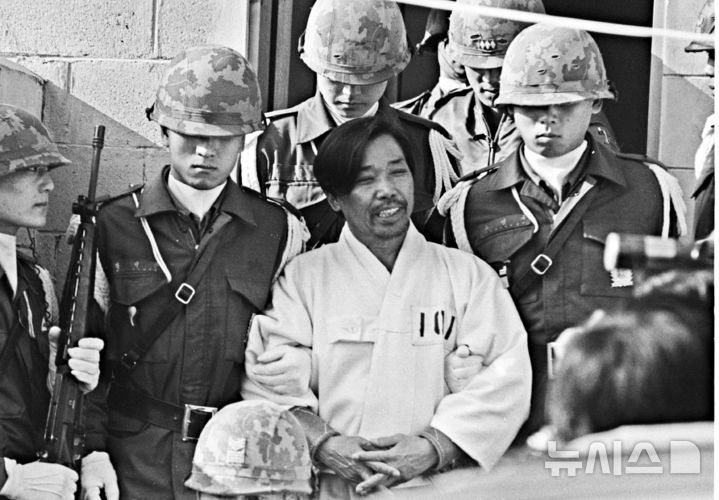 [서울=뉴시스] 박정희 대통령 시해사건 관련자 김재규(전 중앙정보부장) 피고인이 육군본부 계엄 보통군법회의(재판장 김영선 중장)에서 선고공판을 받기 위해 포승에 묶여 걸어오며 웃고 있다. 이날 김재규, 김계원, 박선호, 박흥주, 이기주, 유성옥, 김태원 등 7명은 내란목적살인죄가 적용돼 사형을 선고 받았다. <1979년 12월20일, 권주훈>