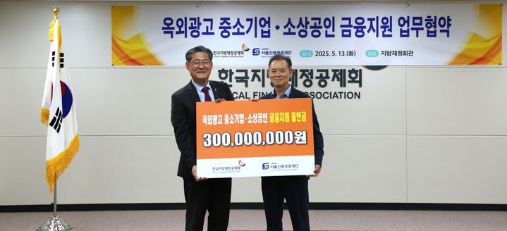 [서울=뉴시스] 최항도 서울신용보증재단 이사장(우)와 정선용 한국지방재정공제회 이사장(좌)이 13일(화) ‘옥외광고 중소기업·소상공인 금융지원 업무협약식’에서 기념판넬을 들고 기념사진을 촬영하고 있다. 2025.05.14. (사진=서울신용보증재단 제공) *재판매 및 DB 금지