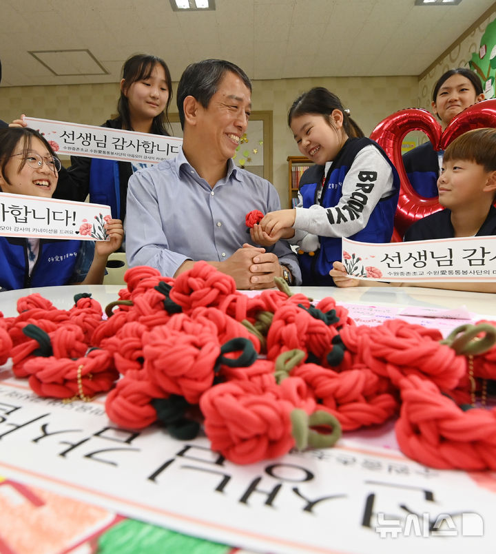 [수원=뉴시스] 김종택 기자 = 스승의 날을 하루 앞둔 14일 경기 수원시 권선구 중촌초등학교에서 통통봉사단 학생들이 직접 만든 카네이션과 감사의 편지를 선생님에게 전달하고 있다. 2025.05.14. jtk@newsis.com