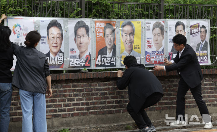 [서울=뉴시스] 김명년 기자 = 서울시선거관리위원회 관계자들이 15일 오전 서울 종로구 예술가의집 담장에 제21대 대통령선거 선거벽보를 부착하고 있다. 선거벽보는 이날부터 전국 8만2900여 곳에 첩부된다. 2025.05.15. kmn@newsis.com