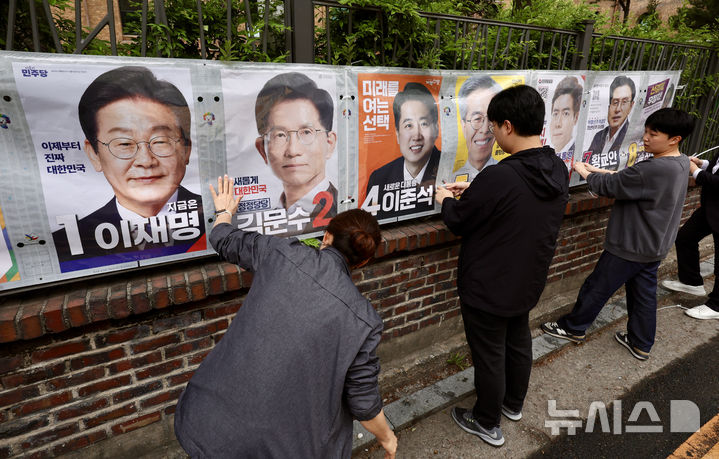 [서울=뉴시스] 김명년 기자 = 서울시선거관리위원회 관계자들이 15일 오전 서울 종로구 예술가의집 담장에 제21대 대통령선거 선거벽보를 부착하고 있다. 선거벽보는 이날부터 전국 8만2900여 곳에 첩부된다. 2025.05.15. kmn@newsis.com