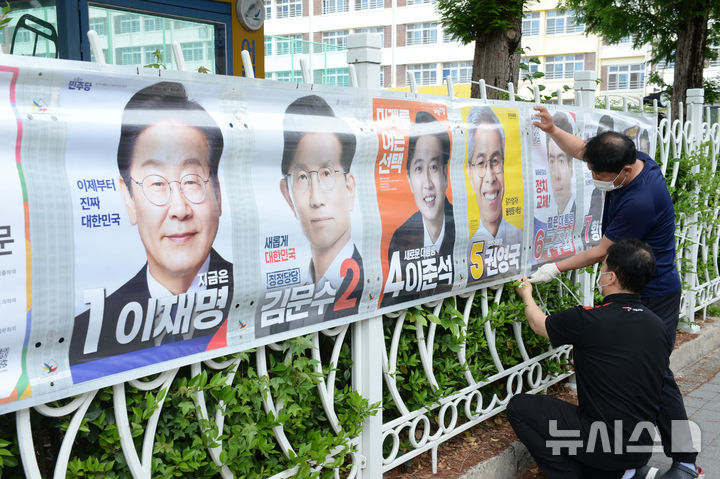 [울산=뉴시스] 배병수 기자 = 울산시선거관리위원회 관계자들이 15일 오전 울산 남구 삼신초등학교 담장에 제21대 대통령선거 선거벽보를 부착하고 있다. 2025.05.15.bbs@newsis.com.