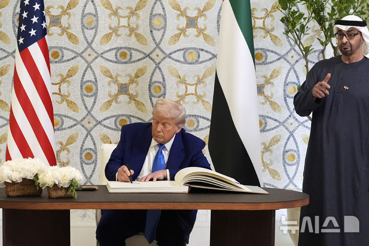 [아부다비=AP/뉴시스] 15일(현지 시간) 아랍에미리트(UAE) 아부다비를 방문한 도널드 트럼프 미국 대통령이 방명록에 서명하는 동안 셰이크 무함마드 빈자이드 알나하얀 대통령이 엄지손가락을 들어 보이고 있다. 2025.05.16.