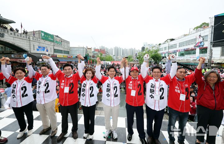 [수원=뉴시스] 조성봉 기자 = 김문수 국민의힘 대선후보와 의원들이 16일 경기도 수원시 팔달구 지동시장에서 열린 유세에서 손을 잡고 시민들에게 지지를 호소하고 있다. 2025.05.16. suncho21@newsis.com