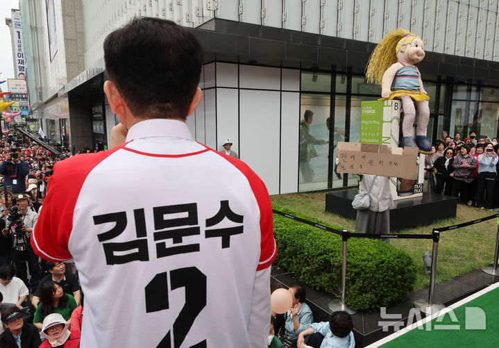 [천안=뉴시스] 조성봉 기자 = 김문수 국민의힘 대선 후보가 16일 충남 천안시 신세계백화점 앞에서 지지를 호소하고 있는 가운데 한 시민이 '권영세, 권성동 은퇴하라' 라고 적은 박스를 들어보이고 있다.(공동취재) 2025.05.16. photo@newsis.com