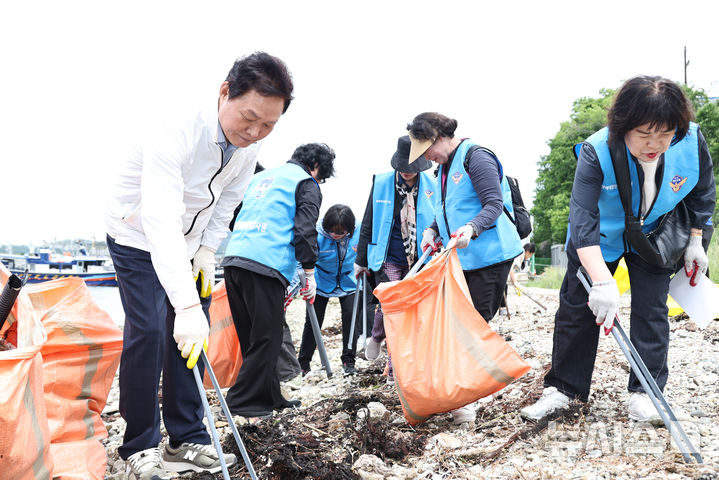 [창원=뉴시스]박완수(왼쪽) 경남도지사가 5월 31일 제30회 바다의 날을 앞둔 21일 오전 창원특례시 진해구 수도 인근 해변에서 진행된 바다 환경 정화 활동에 참여해 해변 쓰레기를 줍고 있다.(사진=경남도 제공)2025.05.21. photo@newsis.com