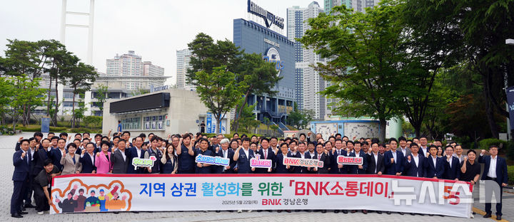 [창원=뉴시스]22일 BNK경남은행 김태한 은행장과 임직원, 창원시 공무원들이 창원NC파크 인근 식당에서 오찬을 하기에 앞서 '지역 상권 활성화를 위한 BNK소통데이' 현수막을 들고 기념촬영하고 있다.(사진=BNK경남은행 제공)2025.05.22. photo@newsis.com
