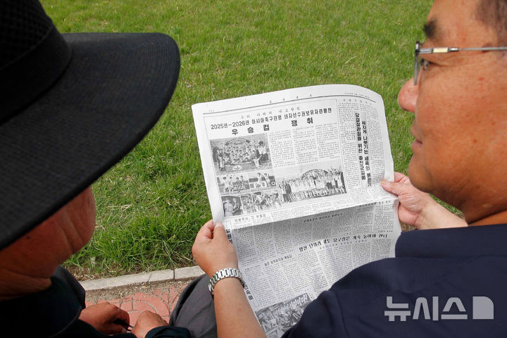 내고향 축구단 우승 기사 읽는 평양 시민들