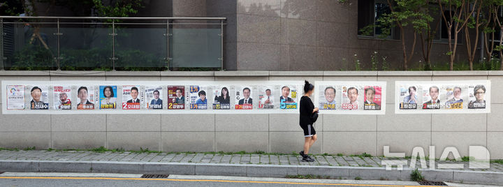 긴 선거벽보 살펴보는 부산 시민