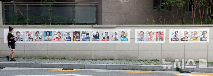 긴 선거벽보 살펴보는 부산 시민