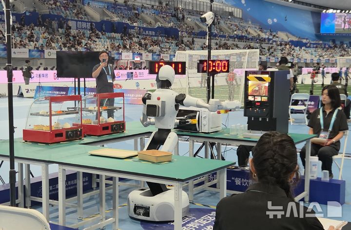로봇운동회에서 전자레인지에 음식 넣고 있는 로봇
