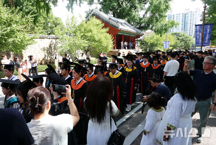 지인들의 축하 받으며 행진하는 학생들