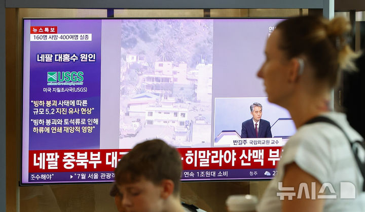 네팔 대홍수 보도 시청하는 시민들